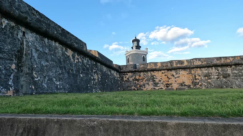 walking through the couryard of castillo san felipe del morro (colorful colonial spanish architecture fort castle in old san juan puerto rico) lighthouse travel beauty trip tourism getaway caribbean