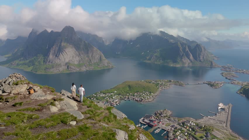 a couple of men and women standing at the top of Reinebringen Lofoten Islands Norway, top of Reinebringen. Touristic path to the Reine viewpoint, Reine, Lofoten, Norway