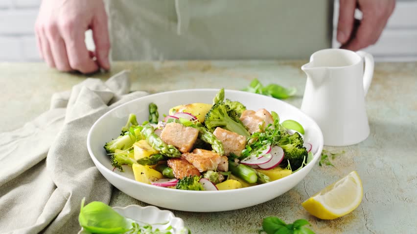 Warm salad with roasted or grilled salmon, potato, asparagus, broccoli and fresh radish. Stock video 4k