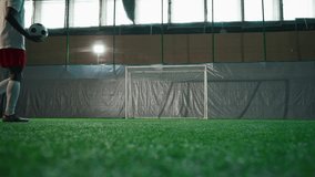 Black soccer player exercising penalty in training hall, scoring goal, back view. Sport training of national team before match and competition, African American man is forward or halfback, empty gate - Powered by Shutterstock - Get 15% off with code: PIKWIZARD15