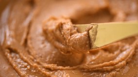 Peanut butter in a glass jar. Creamy smooth peanut butter. Mixing with a knife, making sandwich, organic food. American cuisine. Slow motion  - Powered by Shutterstock - Get 15% off with code: PIKWIZARD15