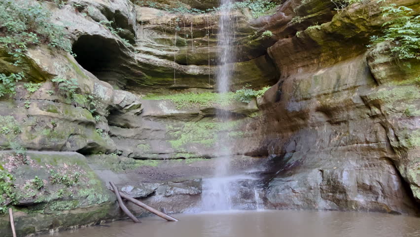 Beautiful waterfall against sandstone cliffs at Starved Rock State Park in Illinois. Panning views from the bottom of the waterfall in the canyon up to the top.