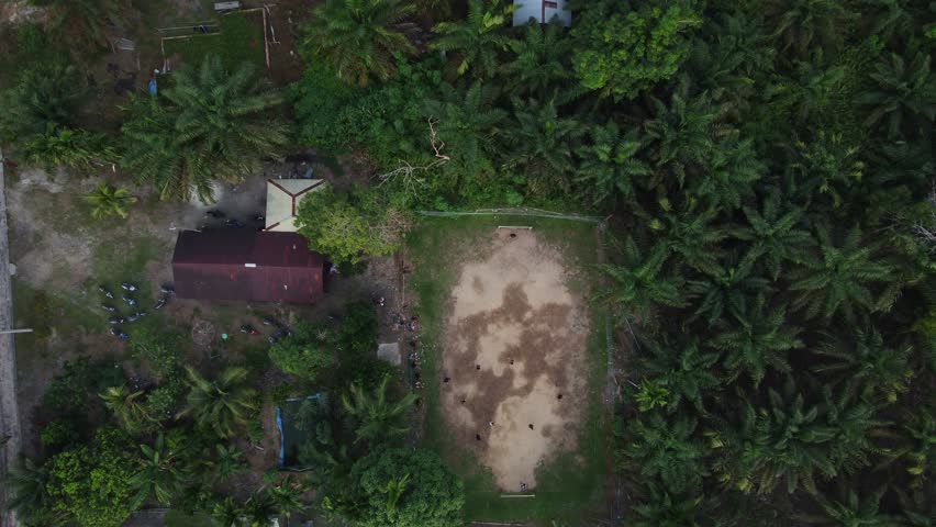Village Youth Playing Soccer on Dirt Field: Aerial View of Rural Recreation