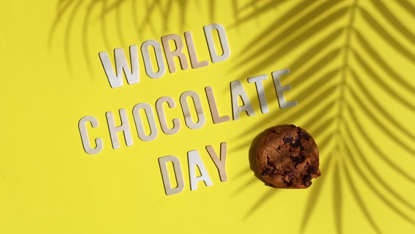 Chocolate cookies and wooden inscription world chocolate day on yellow.