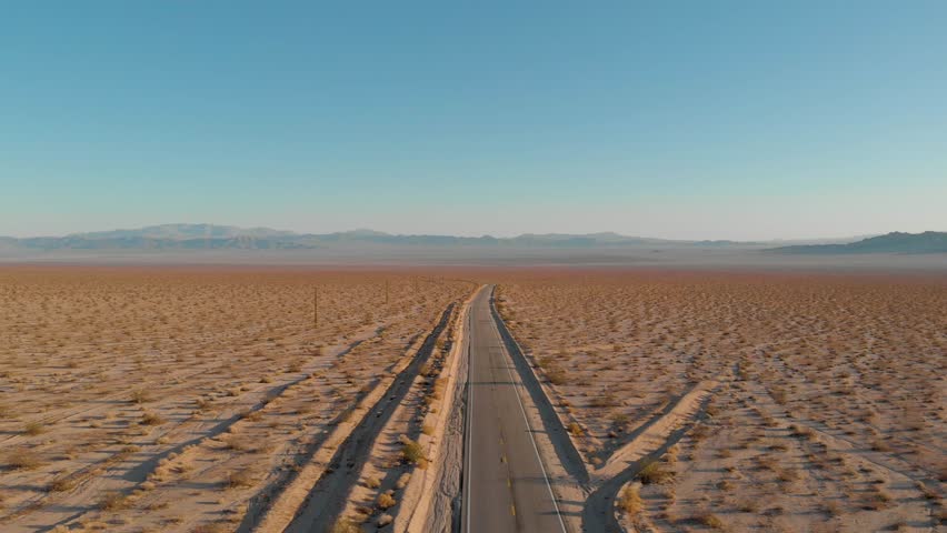 Aerial drone shot over empty highway road and landscape of Mojave Desert in California