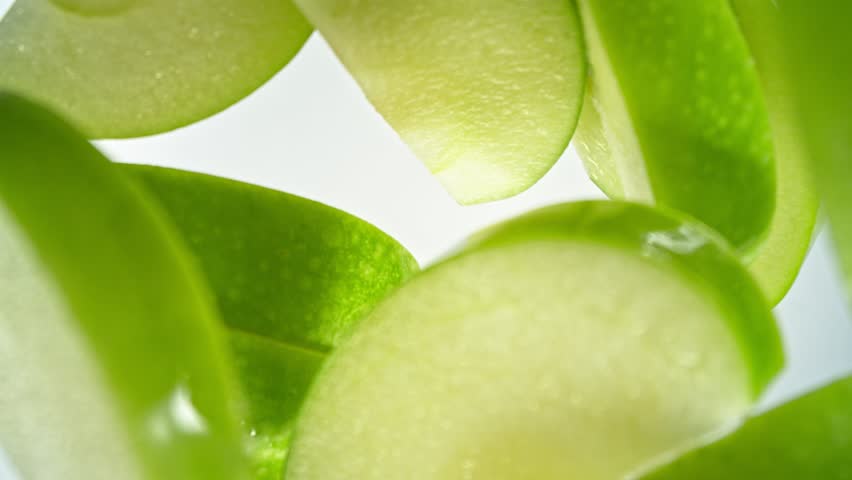Super Slow Motion Shot of Green Apple Cuts Followed by Camera Splashing into Water at 1000 fps.