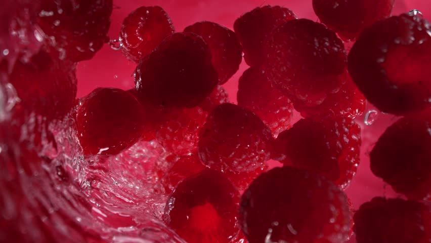 Super Slow Motion Shot of Raspberries Followed by Camera Splashing into Water at 1000 fps.