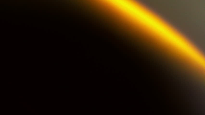 A lens flare with a bright yellow-orange arc transitions from a vivid, almost white-yellow at its brightest point to a deeper orange as it curves.