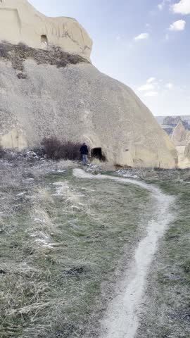 Male walking at winter in Cappadocia region in Turkey by caves in mountain