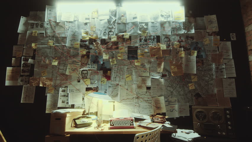 Police officer workplace with retro typewriter and telephone under large evidence board full of printed criminal investigation materials connected by strings in the office at night