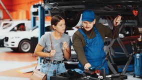 Proficient car mechanic checking operability of auto-element while female client watching him with upset look in auto repair shop - Powered by Shutterstock - Get 15% off with code: PIKWIZARD15