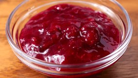 Bright red cranberry sauce pouring down into the glass bowl close up - Powered by Shutterstock - Get 15% off with code: PIKWIZARD15