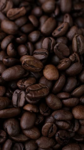 Roast coffee beans falling down in plate. sstkVertical