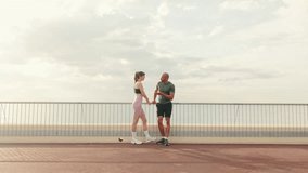 Male and female athletes are talking outdoors on the seafront, walking bridge. Happy fit people are cheerfully talking while working out. Minimalism sport aesthetic - Powered by Shutterstock - Get 15% off with code: PIKWIZARD15