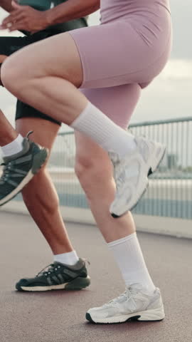 Vertical video, Male and female sportspeople in summer do a full body warm-up, enjoy teamwork, couple goals and motivation. Happy fit people are cheerfully doing sports