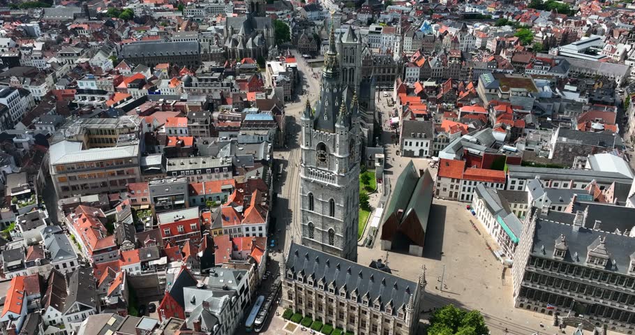 Belfry of Ghent, East Flanders, Ghent, Flemish Region, Belgium, June 2022. Drone aerial ascend jib to top down Birds Eye View of bell tower and ornate spires.