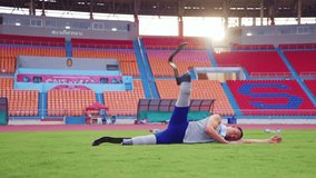 Asian para-athlete with prosthetic blades stretching leg in stadium. Attractive amputee sportsman runner lying down on the glass, warm up before practicing workout for Paralympics running competition. - Powered by Shutterstock - Get 15% off with code: PIKWIZARD15