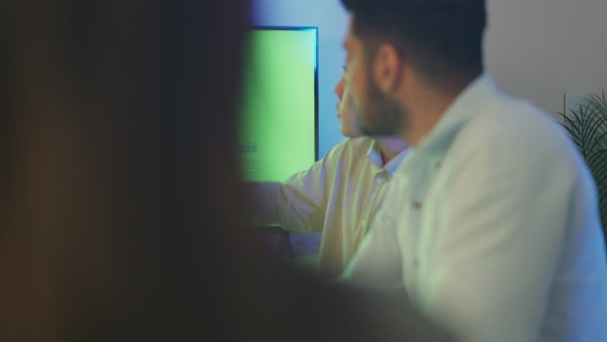 A corporate team is engaged in a strategic discussion around a large screen presenting Net Zero Emission goals, emphasizing renewable energy and sustainability targets.
