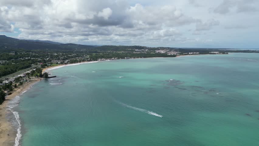 waves crashing on sandy beach in puerto rico (luquillo surf coast coastline) caribbean travel vacation sand getaway (palm trees, hills, kiosk, aerial drone footage) beautiful paradise scenic landscape