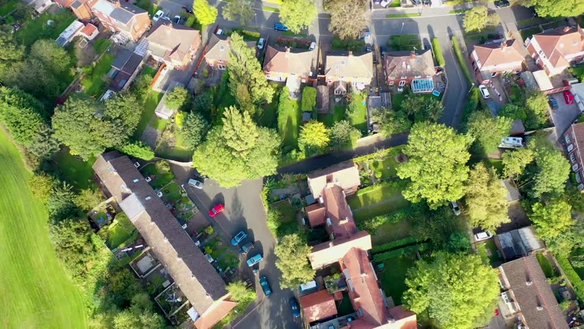 Aerial drone footage of the British town of Meanwood in Leeds West Yorkshire showing typical UK housing estates and rows of houses from above in the spring time on a sunny day