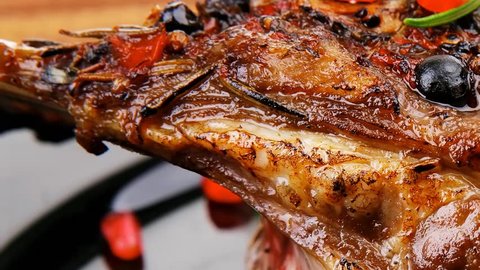 roasted ribs on black plate on wooden table