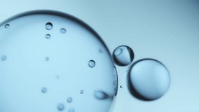 Macro shot of drops of pure fresh melt mountain water with tiny air bubbles, small droplets separate from the large water sphere and fly away on a bright light blue background - Powered by Shutterstock - Get 15% off with code: PIKWIZARD15