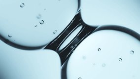 Macro shot of drops of pure fresh melt mountain water with tiny air bubbles, the drops are moving and merging into a large water sphere on a bright light blue background - Powered by Shutterstock - Get 15% off with code: PIKWIZARD15