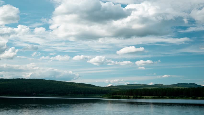 Time-lapse of forming stormy dark clouds over lake