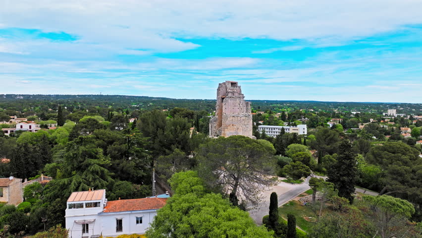 Aerial view of a high stone watchtower, part of the Roman city wall with panoramic views in Nimes. Cultural landmark Tour Magne in Nimes, France.
