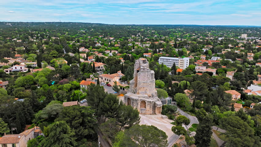 Aerial view of a high stone watchtower, part of the Roman city wall with panoramic views in Nimes. Cultural landmark Tour Magne in Nimes, France.
