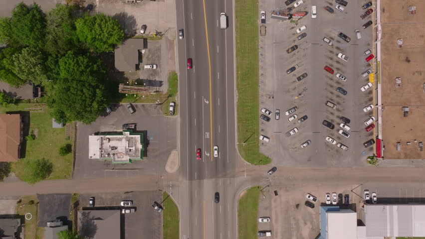 Aerial view of a parking lot and main road in Laurel, USA. Vehicles and buildings from a high angle, capturing urban life and traffic of this american small town