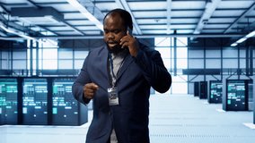 IT technician talking on phone in data center, coordinating server maintenance and troubleshooting tasks. Manager surrounded by server racks and high tech equipment in telephone call, camera A - Powered by Shutterstock - Get 15% off with code: PIKWIZARD15
