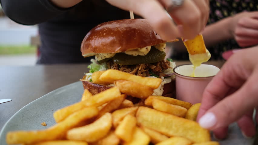Family Enjoying French Fries, Burger And Sauce