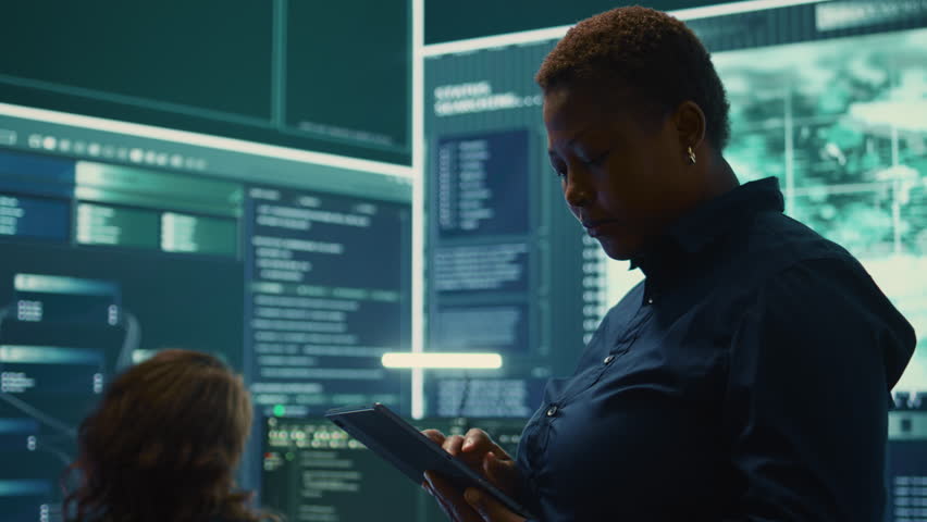 Governmental hackers working on computer network in high tech office, focusing on data security and cyber operations. Cybercrime, data protection and threat detection in secure environment. Camera B. - Powered by Shutterstock - Get 15% off with code: PIKWIZARD15