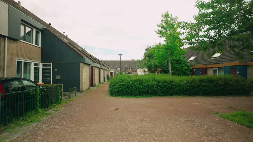 Footage of a typical 60s and 70s residential area in Lelystad, showcasing houses and garages. Footage highlights retro architecture and neighborhood layout. Location: Lelystad, Netherlands