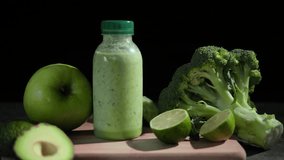 Refreshing green smoothie in bottles on wooden board Hand picks up smoothie from table with avocado, lime, broccoli, apple, cucumber. Perfect for healthy lifestyle content. Ideal smoothie  - Powered by Shutterstock - Get 15% off with code: PIKWIZARD15