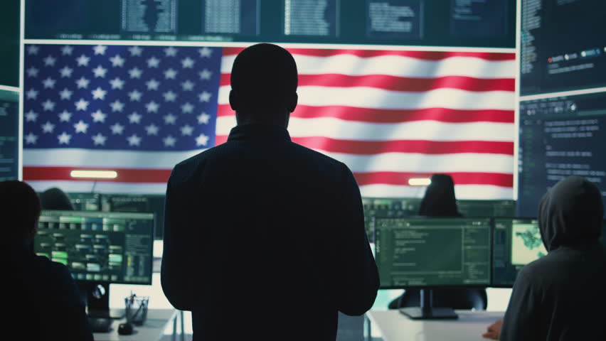 A technical team in a governmental cyber environment with the USA flag. Focus on cybersecurity strategy, threat management and secure operations for national security and digital defense. Camera B.