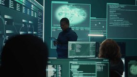 Professional IT expert working in a governmental security operations center, analyzing data on a big screen. Highlighting the importance of cyber security monitoring and threat analysis. Camera B. - Powered by Shutterstock - Get 15% off with code: PIKWIZARD15