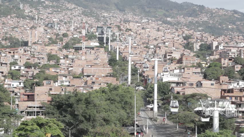 Wide shot of the gondola lift system in Medellin with a look of the houses on a hill in the day