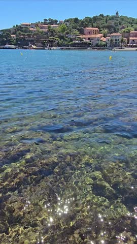 High definition vertical video a person paddling in the pristine waters of Collioure Beach, Plage de Collioure, a picturesque french town on the Mediterranean coast of Southern France