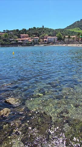 High definition vertical video of people at Collioure Beach, Plage de Collioure, a picturesque french town with clear blue sea on the Mediterranean coast of Southern France
