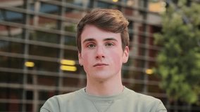 Close up individual portrait of one young male standig outside and looking at camera with serious expression. Teenage student staring front with pensive attitude. Headshot of a isolated real guy. High - Powered by Shutterstock - Get 15% off with code: PIKWIZARD15