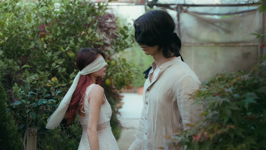 Slow motion cinematic video of two young guys blindfolded crossing eyes while walking