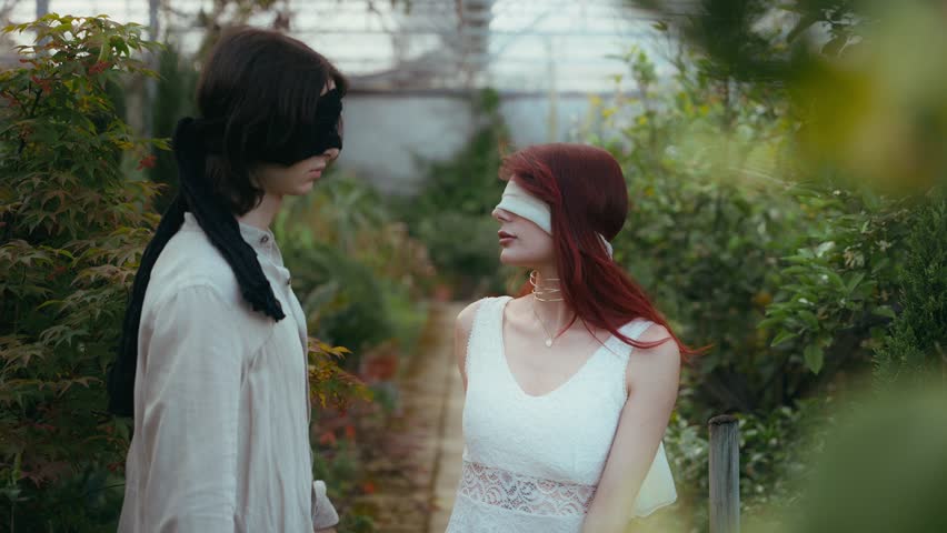 Slow motion cinematic video of two young guys blindfolded crossing eyes while walking