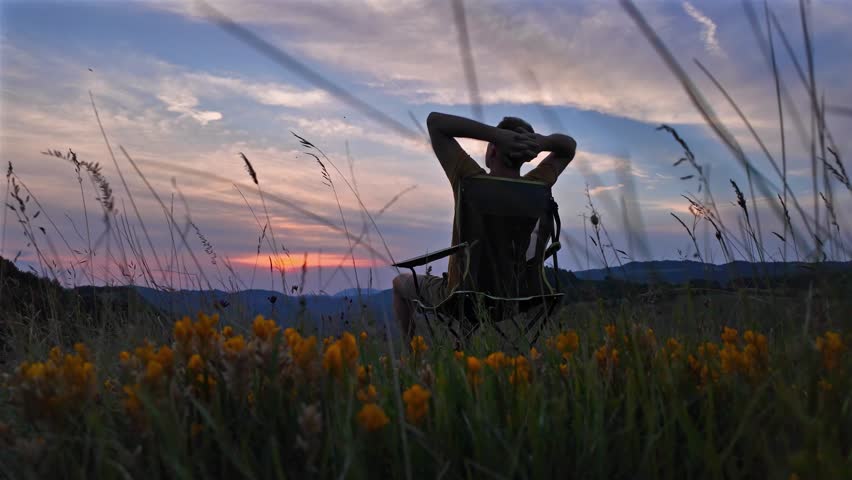 Silhouette of a man looking at the mountain sunset.	

