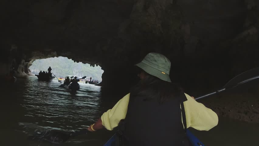 Ha Long Bay, Vietnam - march 8, 2024: Woman exploring calm tropical bay with limestone mountains by kayak. Ha Long Bay, Vietnam