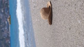 Straw hat on a sand beach of sea. Vertical video. - Powered by Shutterstock - Get 15% off with code: PIKWIZARD15