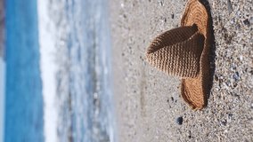 Straw hat on a sand beach of sea. Vertical video. - Powered by Shutterstock - Get 15% off with code: PIKWIZARD15