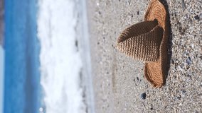 Straw hat on a sand beach of sea. Vertical video. - Powered by Shutterstock - Get 15% off with code: PIKWIZARD15