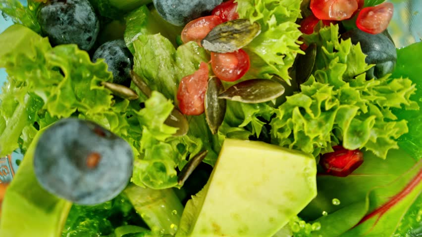 Super slow motion of mixing pieces of fruit and vegetables in blender, camera movement, top shot. Filmed on high speed cinema camera, 1000 fps.